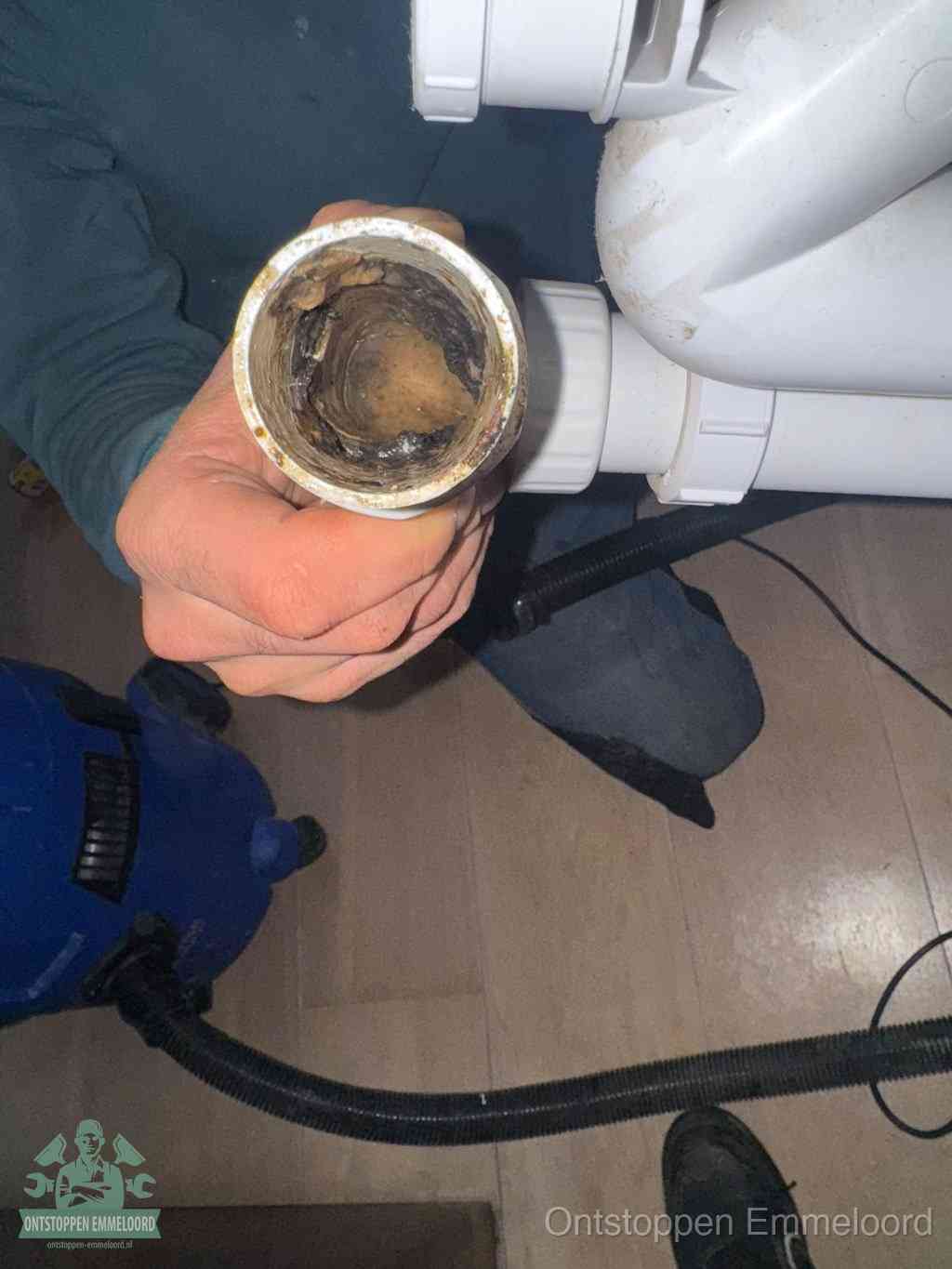 Een losgekoppeld PVC-afvoerbuisstuk dat van binnen volledig is dichtgeslibd met vet en vuil, de meest voorkomende oorzaak van verstoppingen in Emmeloord