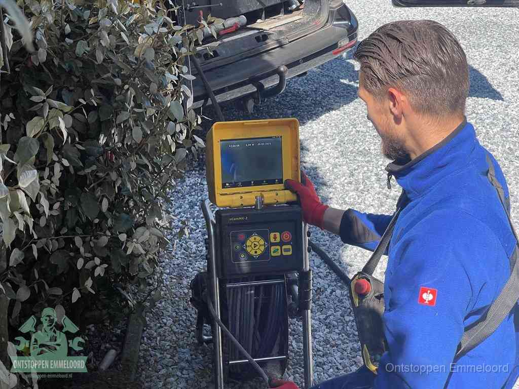 Een monteur bedient een rioolinspectiecamera met monitor en haspel om de verstopping in beeld te brengen in Emmeloord