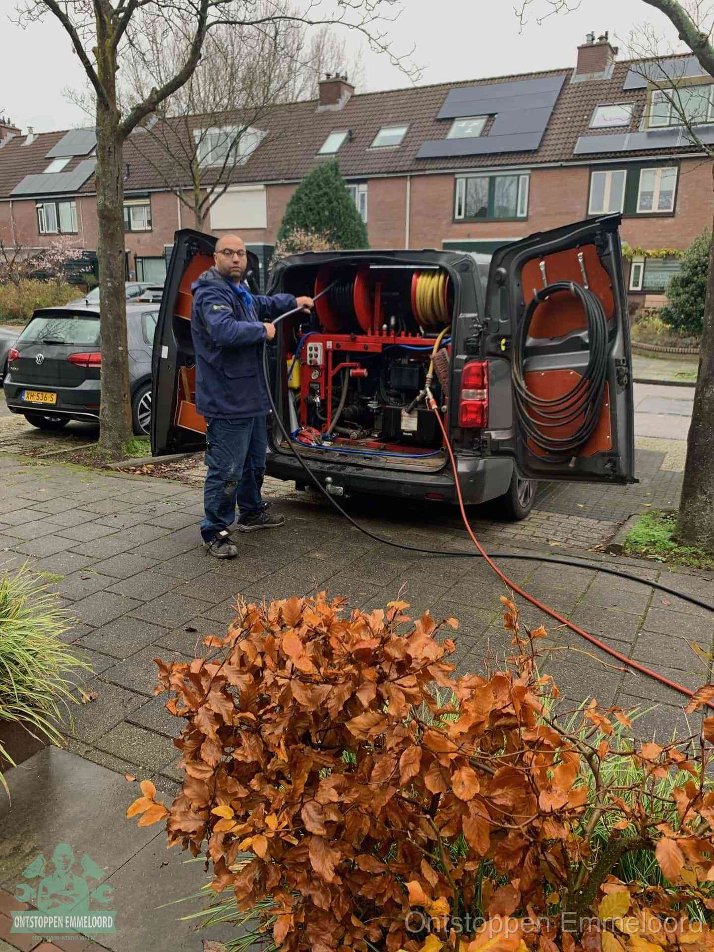 Een monteur staat bij zijn open bestelbus met hogedruk-rioolreinigingsapparatuur, klaar om binnen 30 minuten uit te rukken voor een spoedverstopping in Emmeloord